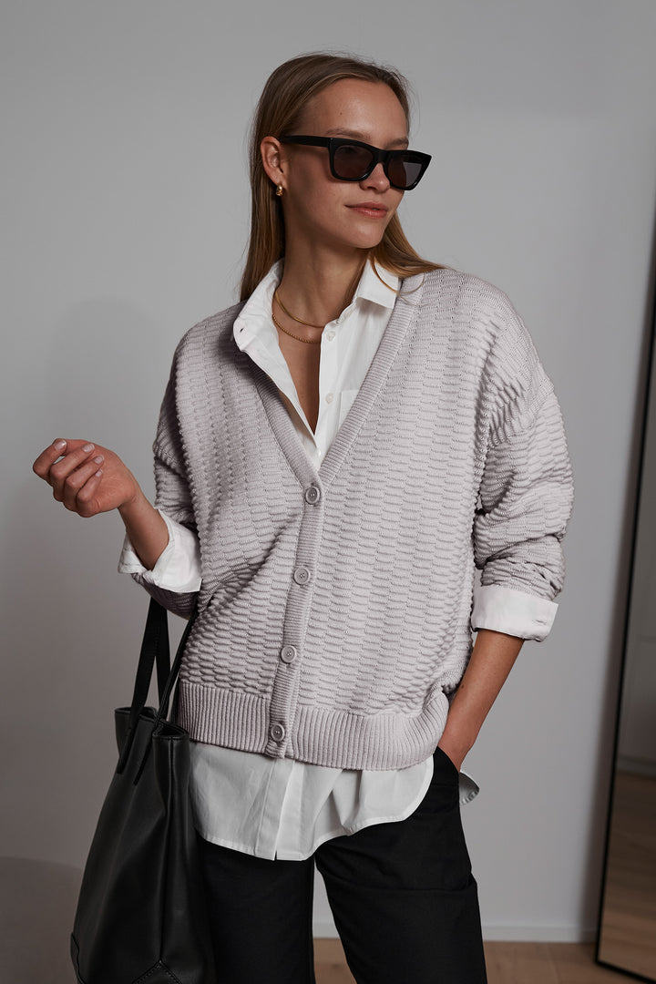 Grey knitted organic cotton cardigan coat, offering a relaxed fit and breathable fabric for eco-friendly, stylish outerwear.