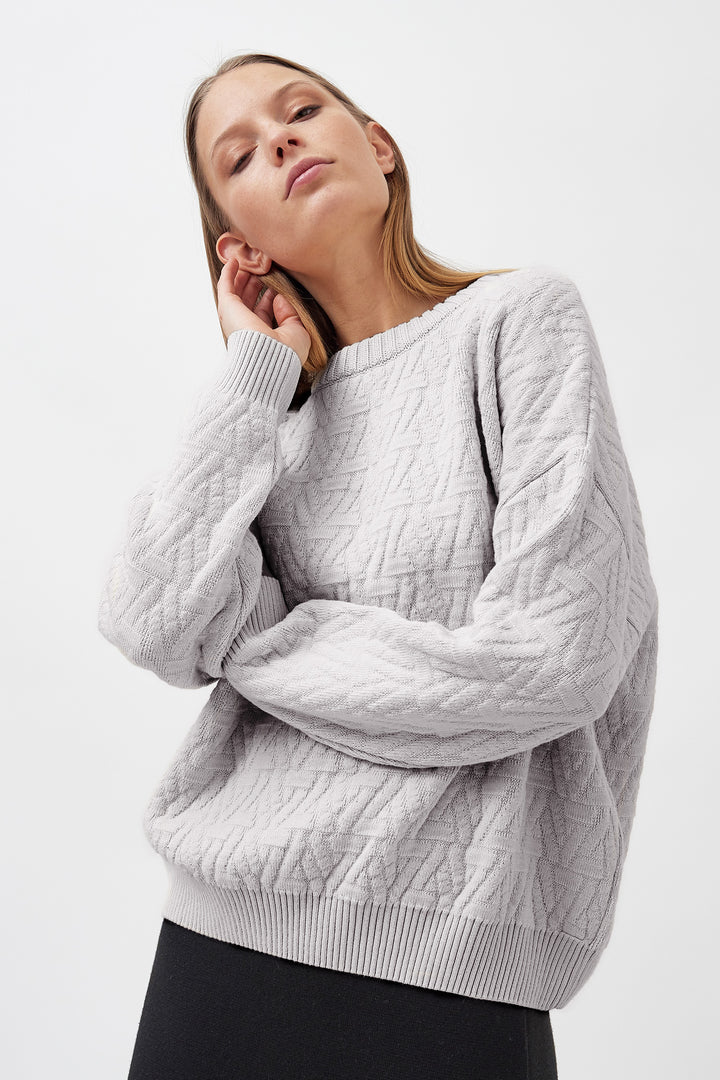 Knitted organic cotton triangle pullover in grey, showcasing a unique textured triangle pattern with a minimalist, relaxed fit design.